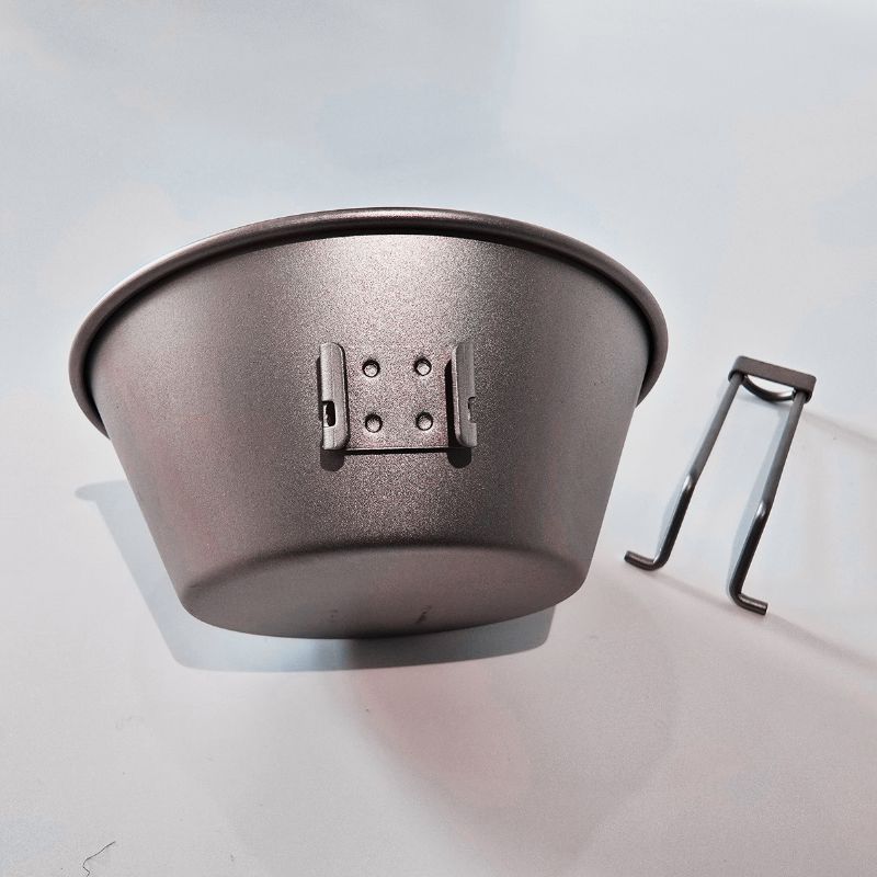 Metal feed bowl with a holder on a light gray background