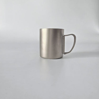 Silver metal mug on a light gray background