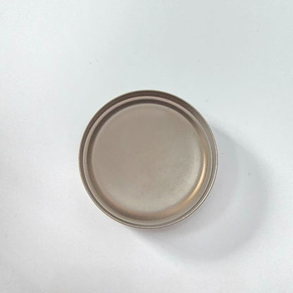 Round ceramic plate with a brownish-beige glaze on a white background