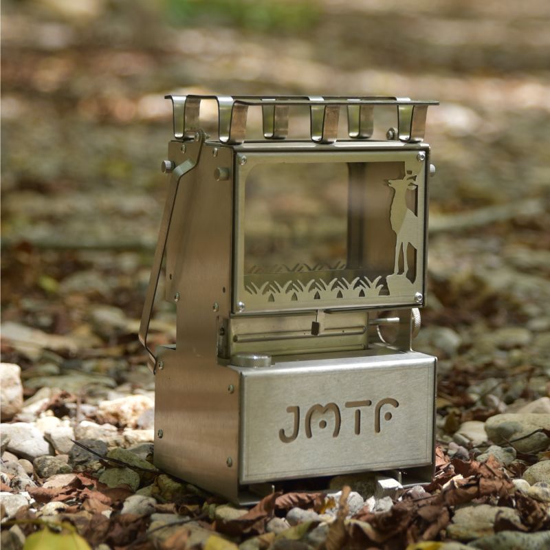 Portable metal stove with 'JMTF' branding on a natural background