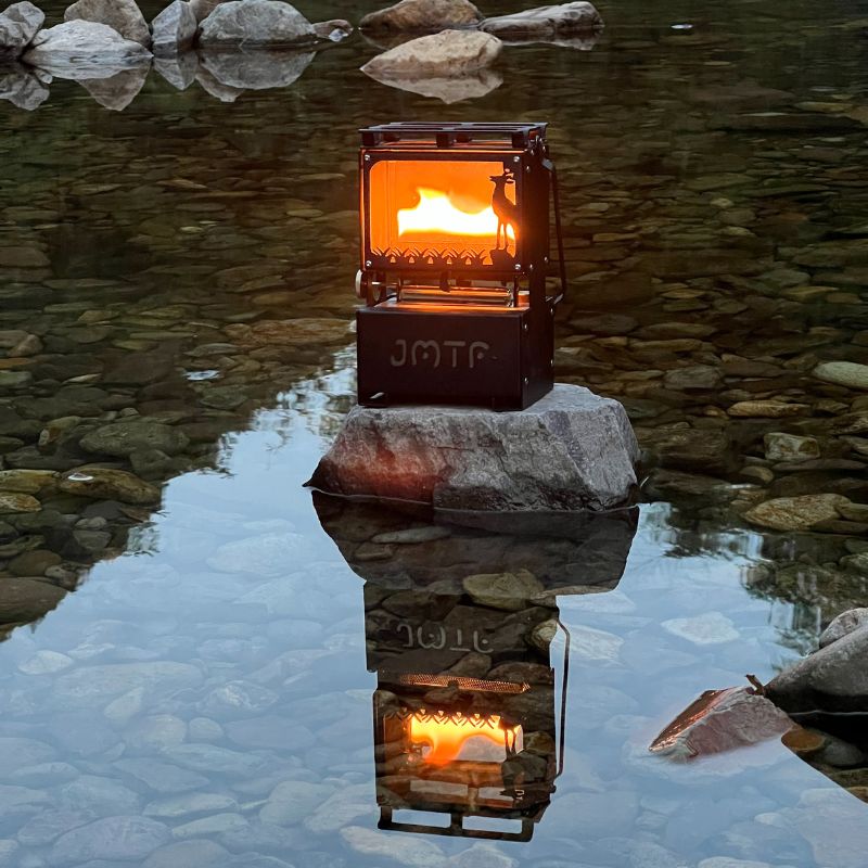 Portable stove with visible brand logo on a rock in a reflective water setting