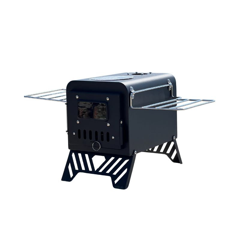 Black carbon steel portable folding camping wood stove with side shelves, chimney pipe, and glass viewing window on white background