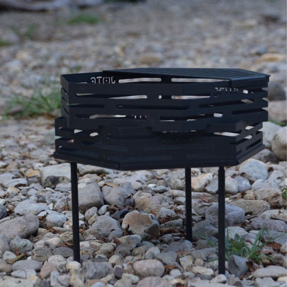 Black metal grill on a rocky ground