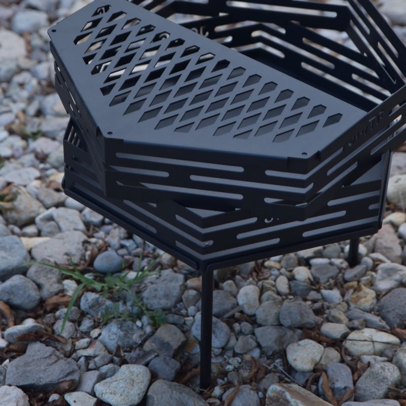Black metal fire pit on a rocky ground