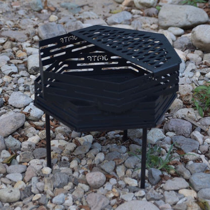 Black metal fire pit on a rocky ground
