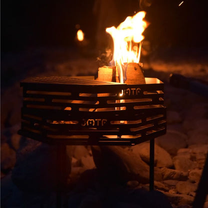 Portable fire pit with flames on a dark background