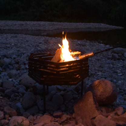 Fire pit with flames on a rocky ground at night