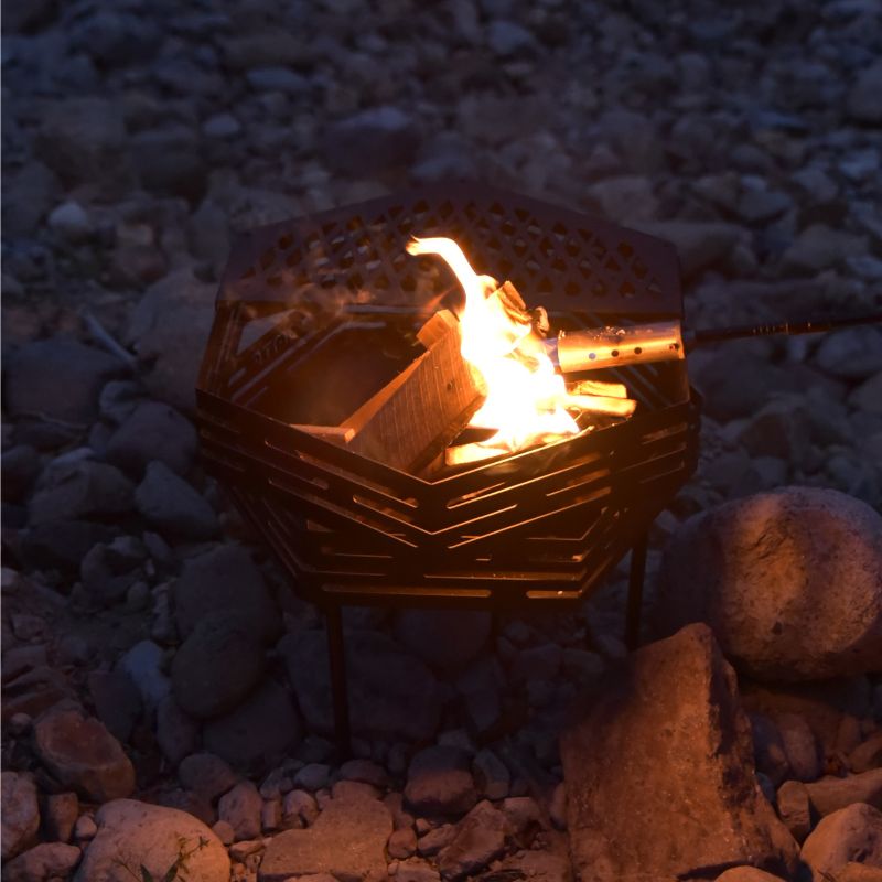 Small fire pit with flames on a rocky ground