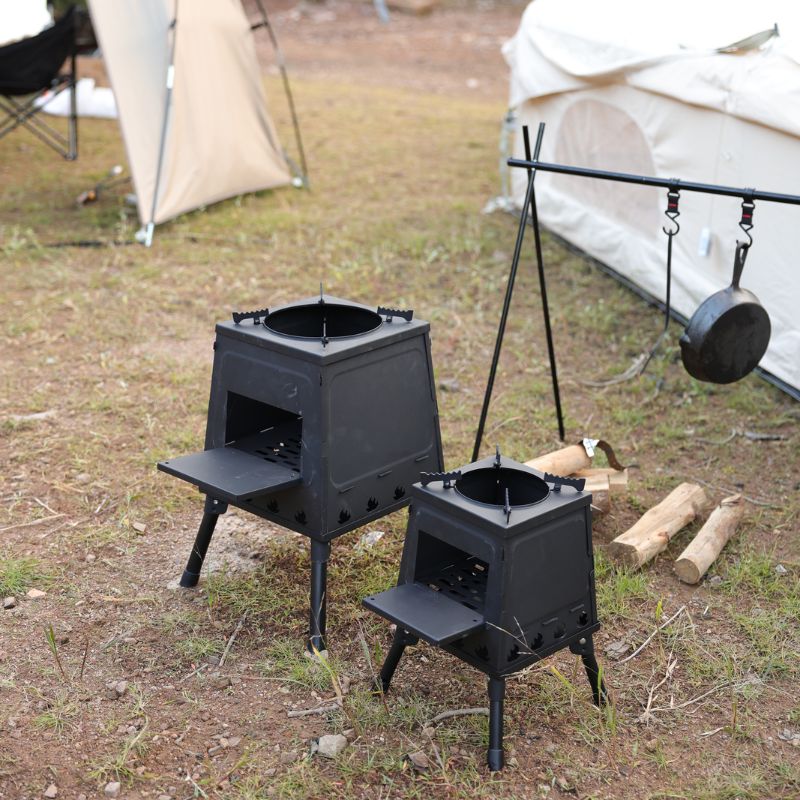 Two black camping stoves with a tent in the background