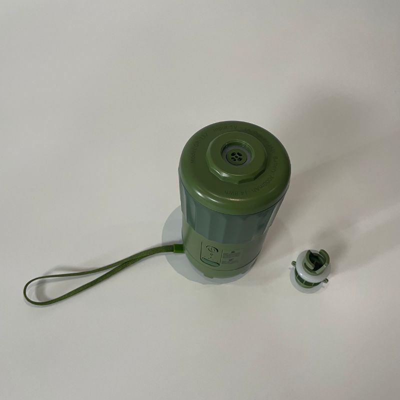 Green cylindrical container with a handle on a white background