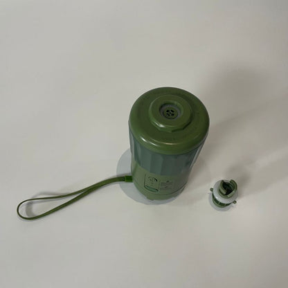 Green cylindrical container with a handle on a white background