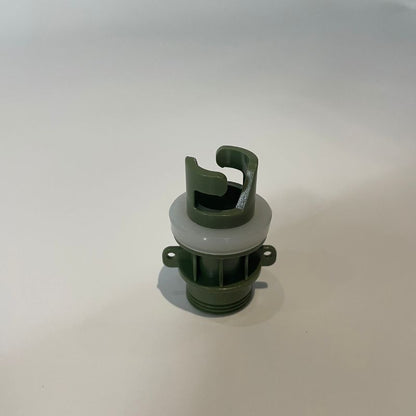 Green and white plastic component on a light gray background