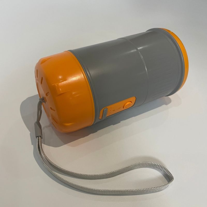 Orange and gray flashlight with a strap on a white background