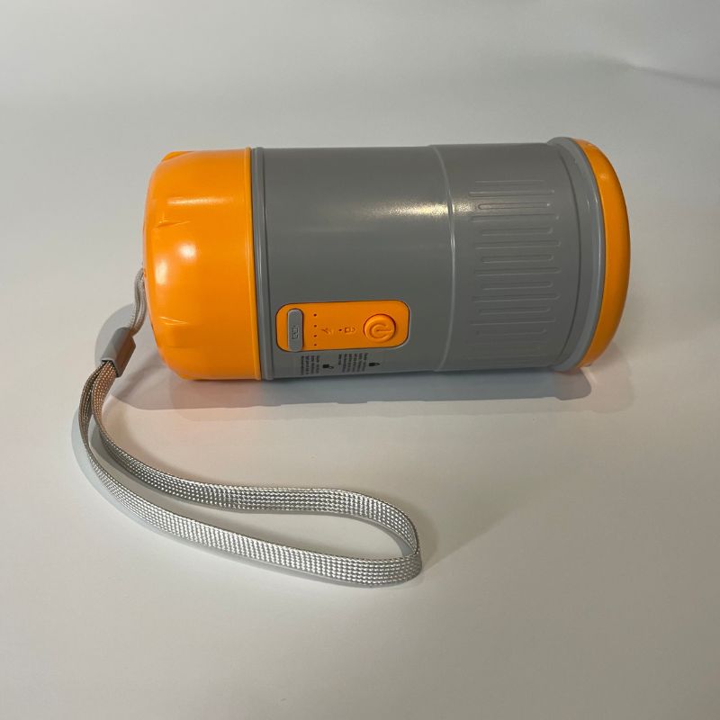 Orange and gray flashlight with a strap on a white background