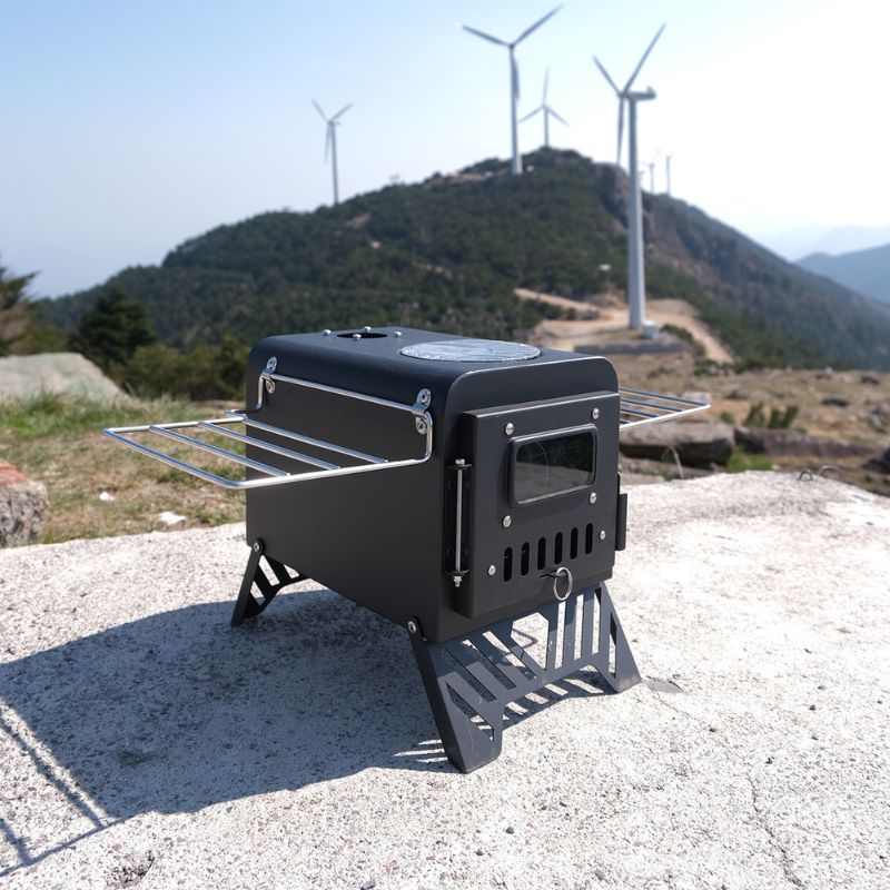 Portable stove on a mountain with wind turbines in the background