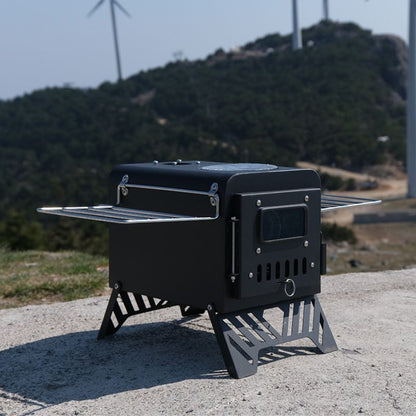 Portable black stove on a concrete surface with a mountainous background