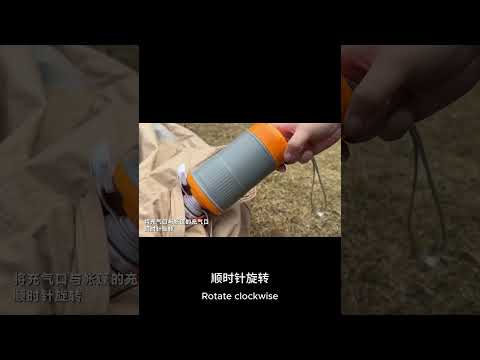 Close-up of the GR-152 wireless high-speed inflator being secured to a beige camping tent for fast inflation