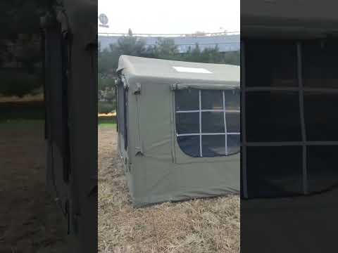 Green TC cotton inflatable glamping tent set up outdoors in a grassy field with natural background