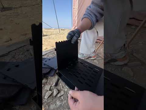 Black foldable camping wood stove installation instructions, with glass observation window and folding bracket, can be set up outdoors.
