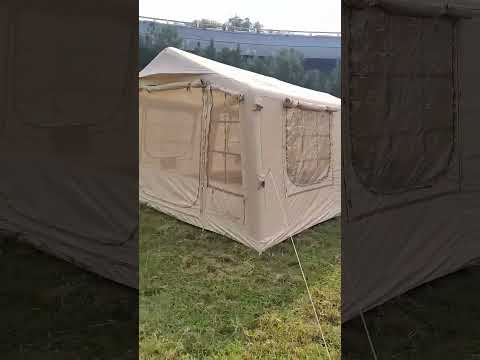 Khaki TC cotton inflatable glamping tent set up outdoors on grass with natural background and guy ropes